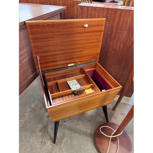 87 - A teak sewing box, demi lune hall table and a teak standard lamp