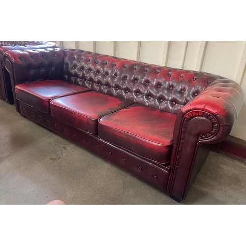 101 - An oxblood faux red leather Chesterfield sofa