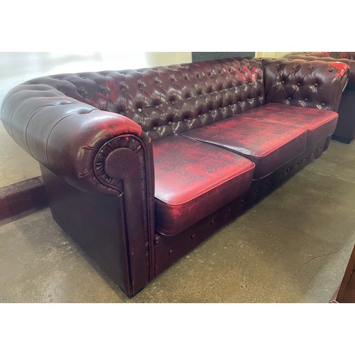 103 - An oxblood faux red leather Chesterfield sofa