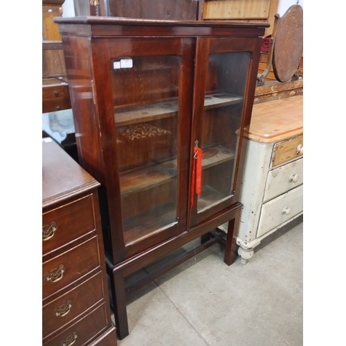 187 - An Edward VII beech two door bookcase on stand