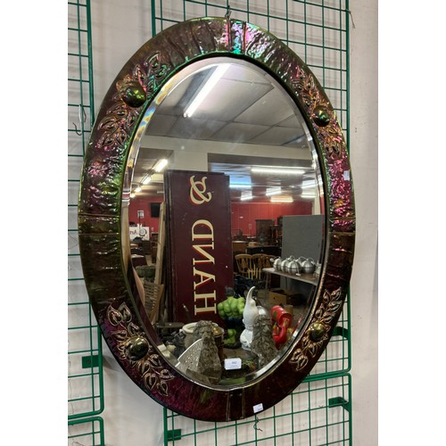 342 - An Art Nouveau hammered copper oval framed mirror