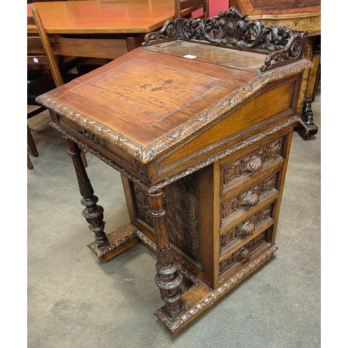 115 - A Victorian Jacobean Revival carved oak Davenport