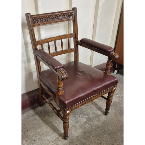 165 - A Victorian Aesthetic Movement carved oak and oxblood red leather library chair