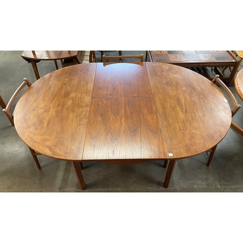 44 - A teak circular extending dining table and three Meredew dining chairs