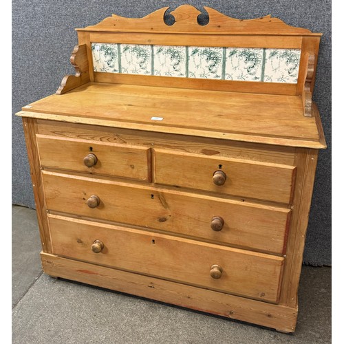 105 - A Victorian pine and tiled back chest of drawers