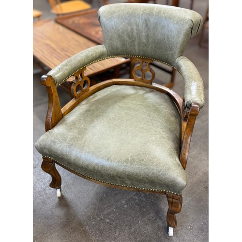 121B - A Victorian walnut and leather upholstered open armchair