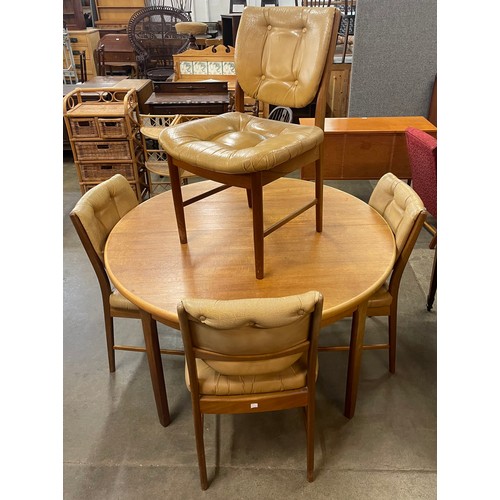 51 - A teak circular extending dining table and four chairs