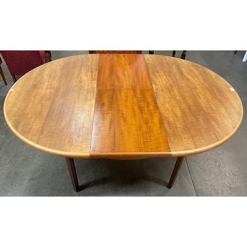 51 - A teak circular extending dining table and four chairs