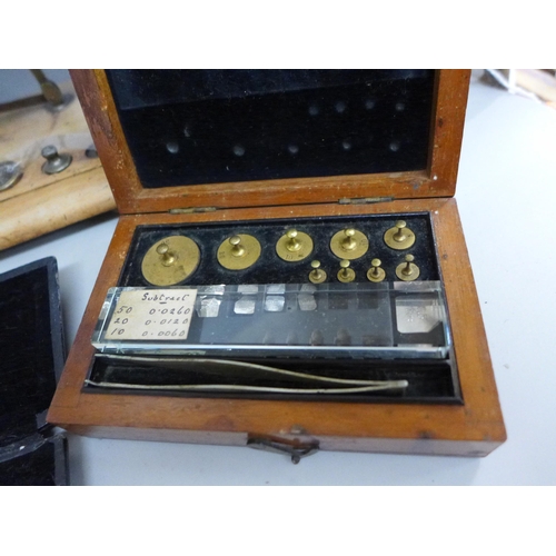 682 - An apothecary pill mould/maker, a set of cased weights, set of postal scales and a small cased set o... 