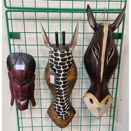 319 - Three African carved wooden masks,  including a giraffe