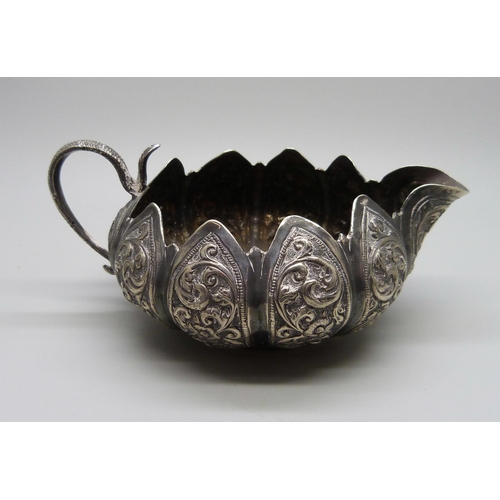 828 - An embossed Indian silver jug, 94g