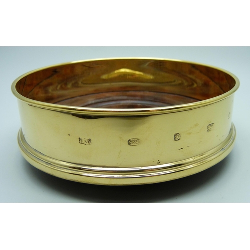 832 - A silver gilt bottle coaster