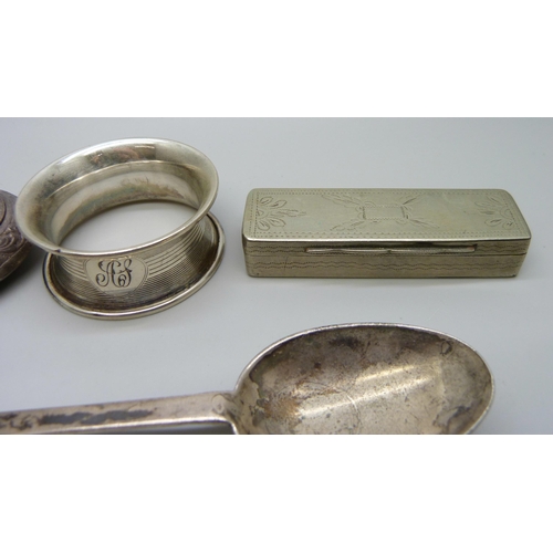 843 - A silver plated snuff box, an embossed white metal pill box, a silver spoon and a silver napkin ring... 