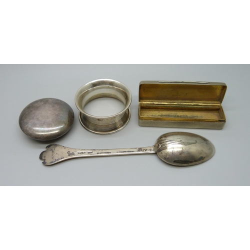 843 - A silver plated snuff box, an embossed white metal pill box, a silver spoon and a silver napkin ring... 