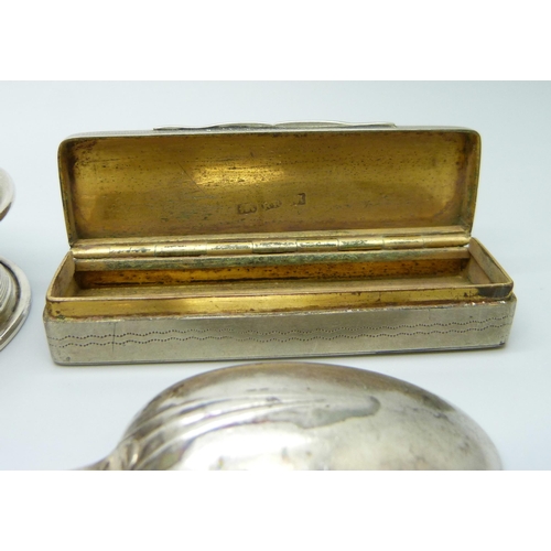 843 - A silver plated snuff box, an embossed white metal pill box, a silver spoon and a silver napkin ring... 