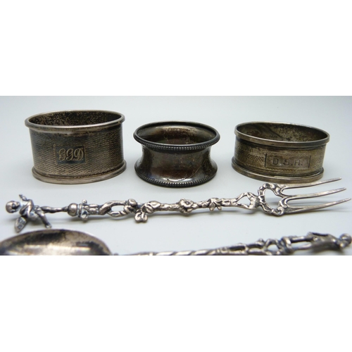 874 - Three silver napkin rings, an 800 silver fork and a continental white metal spoon, 59g