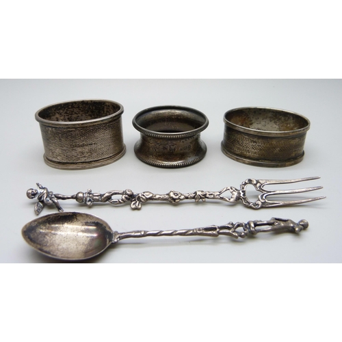 874 - Three silver napkin rings, an 800 silver fork and a continental white metal spoon, 59g