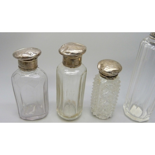 888 - Four glass scent bottles with silver tops, tops a/f, dented