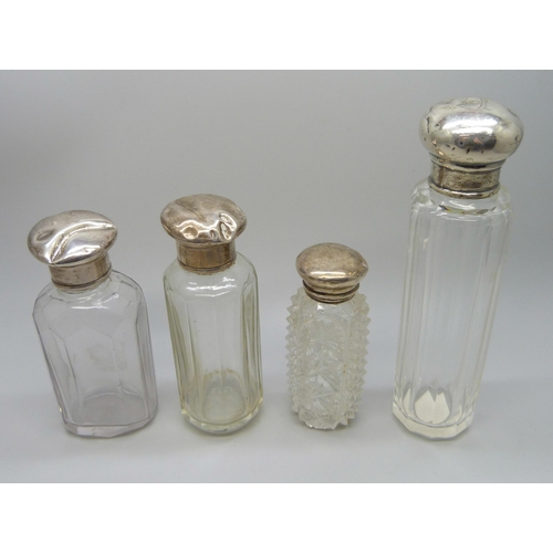 888 - Four glass scent bottles with silver tops, tops a/f, dented