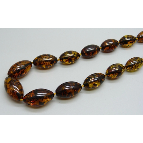 957 - A string of Baltic amber beads, silver mounted