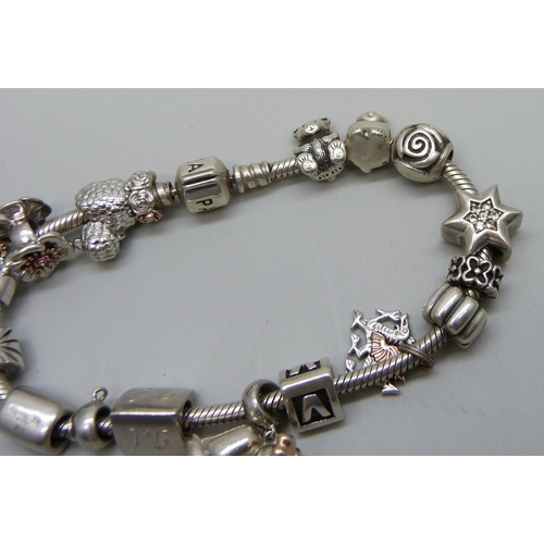 961 - A silver Pandora bracelet with eight Clogau charms, four Pandora charms and others