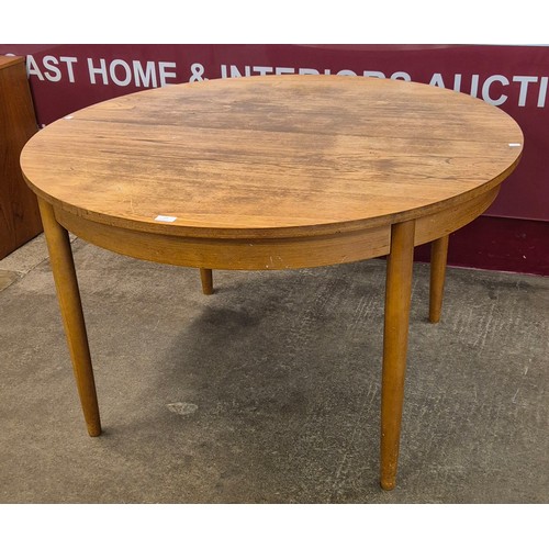 23 - A teak circular extending dining table