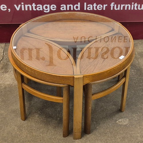 32 - A Nathan Trinity teak and glass topped circular nest of tables