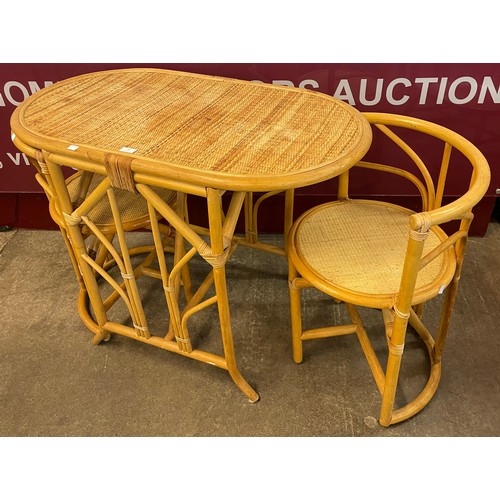 82 - A bamboo and rattan table and two chairs