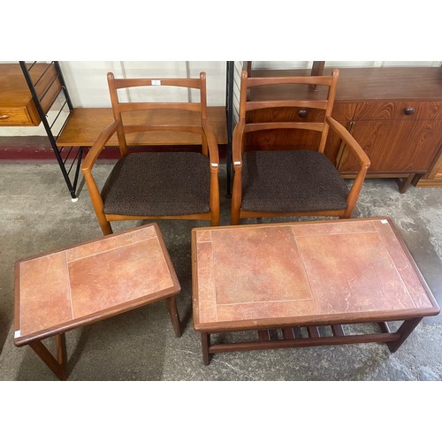 99 - A pair of teak elbow chairs and two tiled topped teak tables