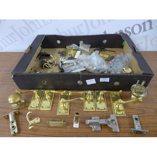 2250 - A box of brass door fittings including handles, hinges, coat hook, locks etc.