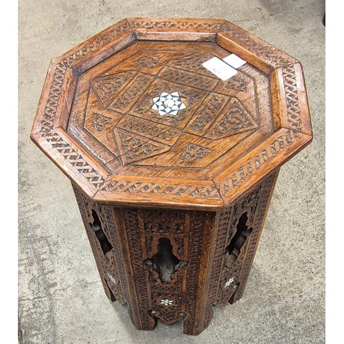 124 - A small Moorish carved hardwood and mother of pearl inlaid octagonal occasional table