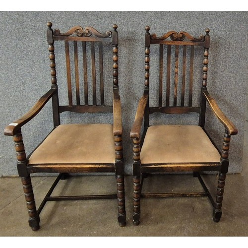 129 - A pair of early 20th Century carved oak elbow chairs