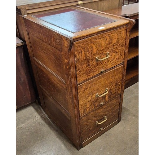 135 - An early 20th Century and red leather topped three drawer filing cabinet