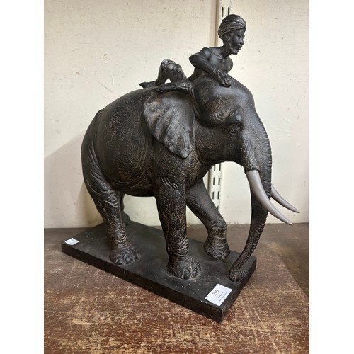 296 - A resin figure of a man riding an elephant