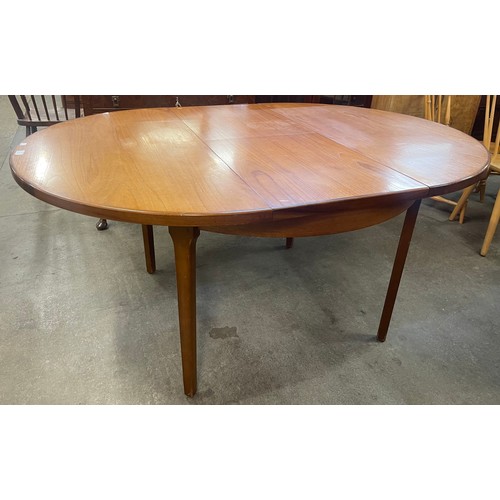 65 - A teak circular extending dining table