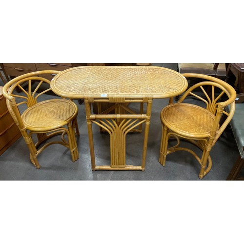 104 - A bamboo and rattan table and two chairs