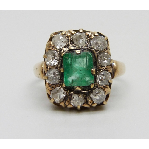 1003 - An early Victorian yellow metal ring set with a central emerald and ten diamonds, approximately 1.2c... 