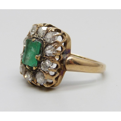 1003 - An early Victorian yellow metal ring set with a central emerald and ten diamonds, approximately 1.2c... 