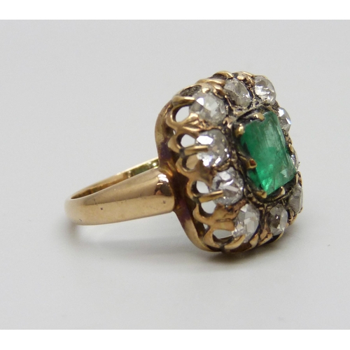 1003 - An early Victorian yellow metal ring set with a central emerald and ten diamonds, approximately 1.2c... 