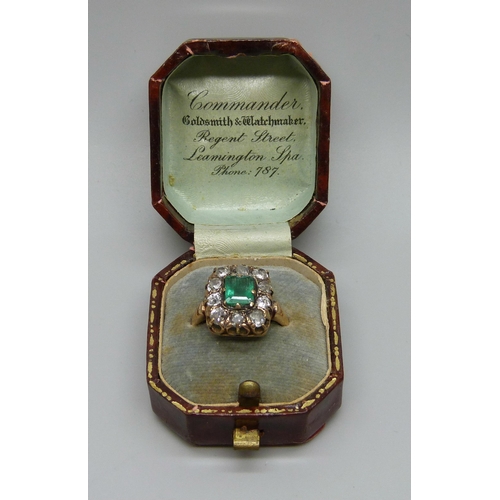 1003 - An early Victorian yellow metal ring set with a central emerald and ten diamonds, approximately 1.2c... 