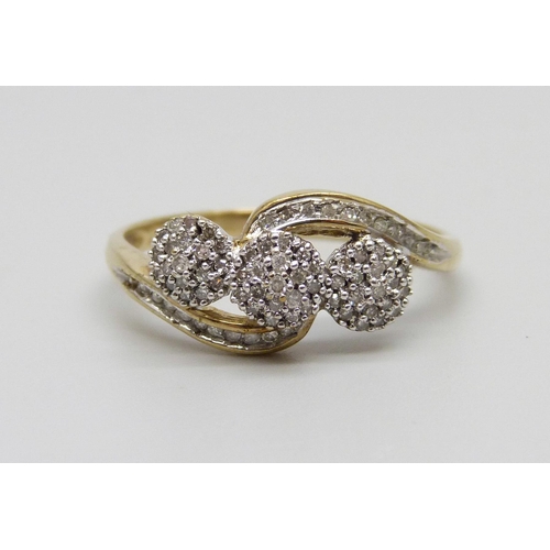 1011 - A 9ct gold and diamond triple cluster ring with diamond set shoulders, 2.6g, U/V