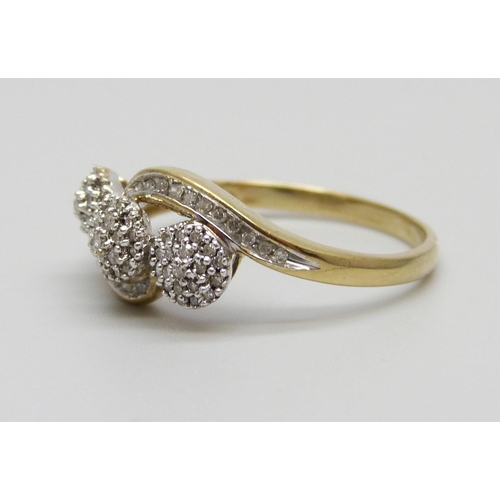 1011 - A 9ct gold and diamond triple cluster ring with diamond set shoulders, 2.6g, U/V