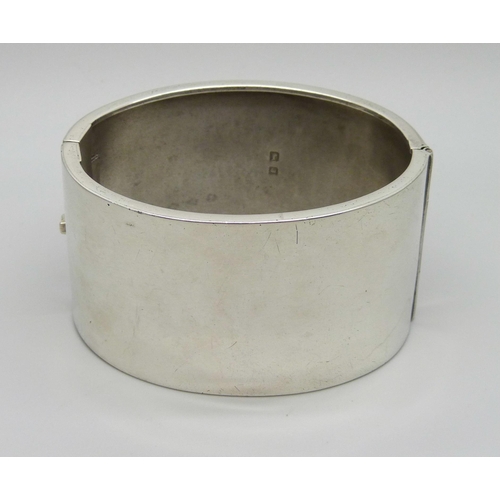 1022 - A silver bangle with engraved dog design, Birmingham, 1933, 49g