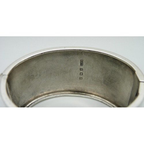 1022 - A silver bangle with engraved dog design, Birmingham, 1933, 49g