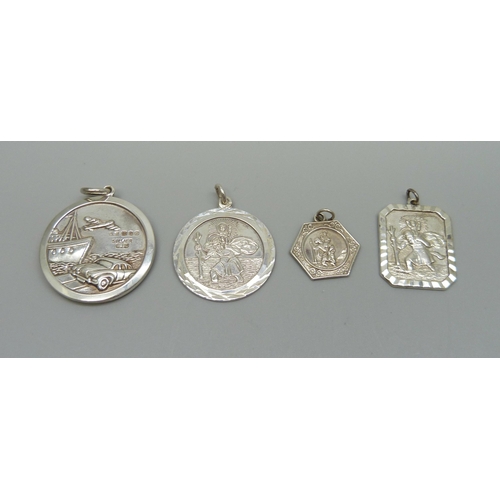 1024 - Four silver St. Christopher pendants including a 3cm Georg Jensen example, 32g