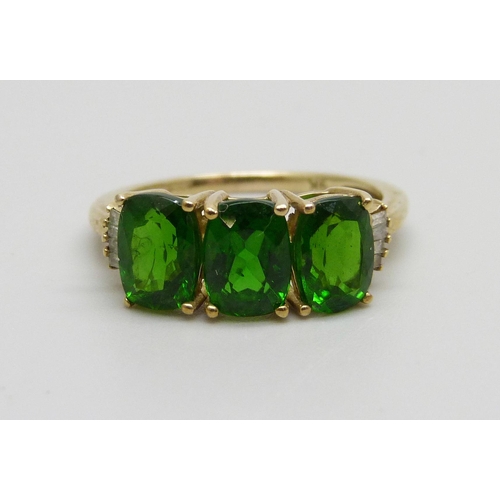 1073 - A 9ct gold ring set with three green stones, 2.4g, O