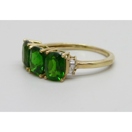 1073 - A 9ct gold ring set with three green stones, 2.4g, O