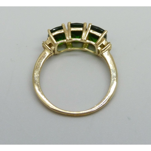 1073 - A 9ct gold ring set with three green stones, 2.4g, O