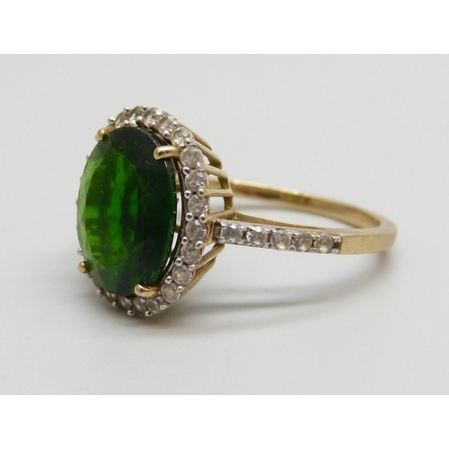 1075 - A 9ct gold ring set with a central green stone and white spinel halo and shoulders, 3.4g, P/Q