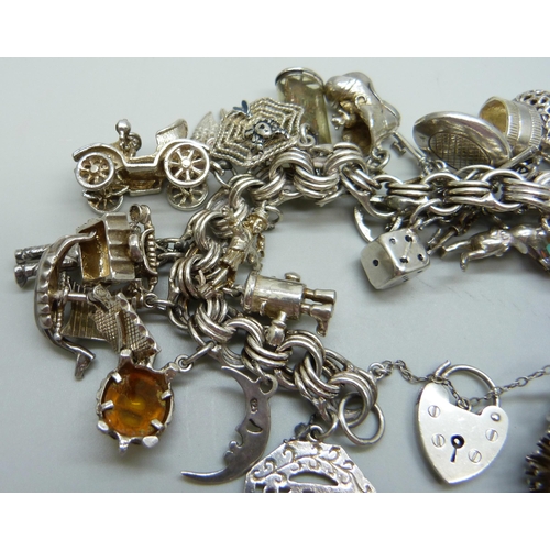 1112 - A large charm bracelet, approximately 26 charms, bracelet and the majority of charms test as silver,... 